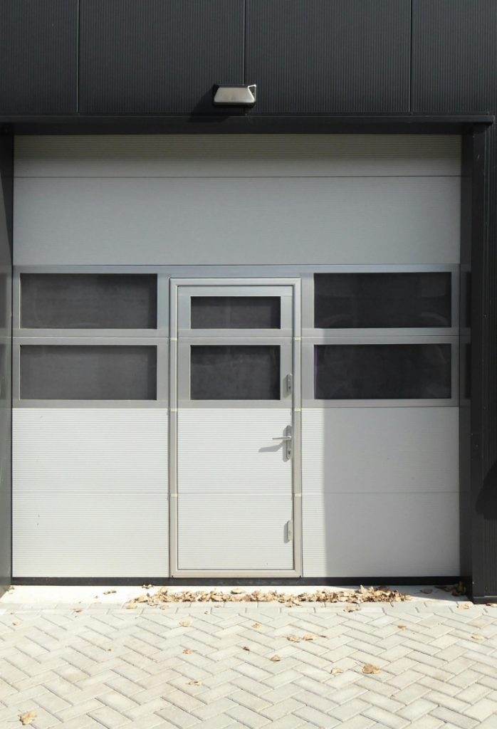 Modern industrial entrance featuring a sleek door design and large windows in a contemporary building setting Modern industrial entrance featuring a sleek door design and large windows in a contemporary building setting