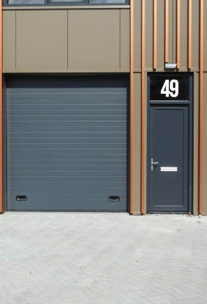 Modern industrial building entrance with roll-up door and side entrance Modern industrial building entrance with roll-up door and side entrance