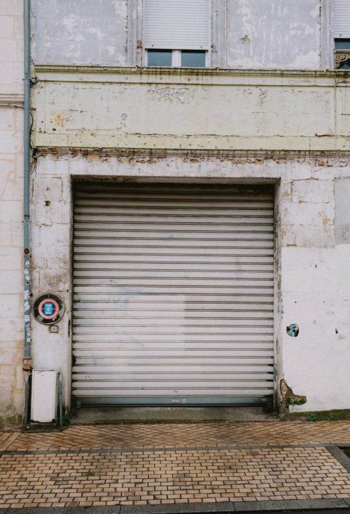 Rustic warehouse entrance with a shutter door and vintage details in an urban setting during the day Rustic warehouse entrance with a shutter door and vintage details in an urban setting during the day