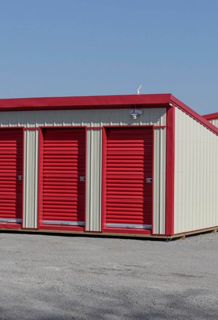 Storage facility with red and white units under a clear blue sky in a suburban area Storage facility with red and white units under a clear blue sky in a suburban area