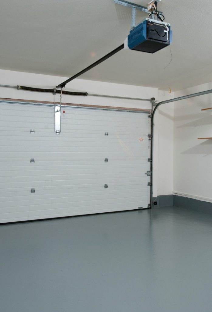 Spacious garage interior with a clean floor and automatic door opener in a modern home Spacious garage interior with a clean floor and automatic door opener in a modern home