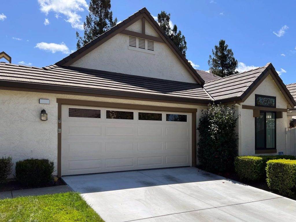 Family home with a modern facade and well-maintained yard on a sunny day Family home with a modern facade and well-maintained yard on a sunny day