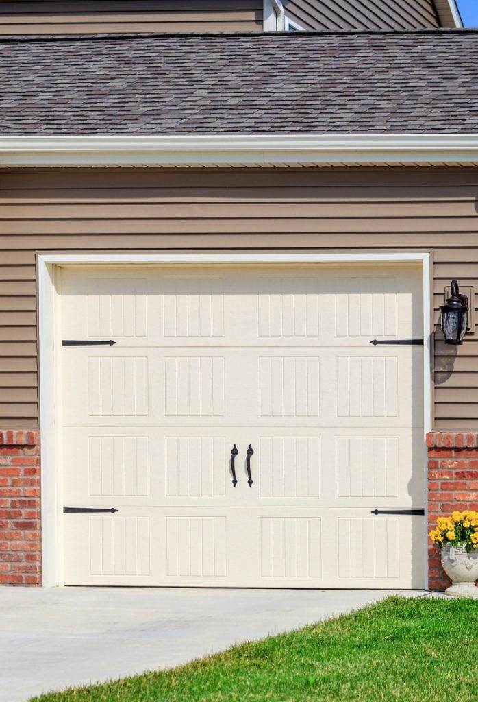 Beautiful garage door with elegant handles and classic design in a residential home located in a suburban area Beautiful garage door with elegant handles and classic design in a residential home located in a suburban area